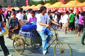 河大校园里，老生志愿者在帮新生运行李。